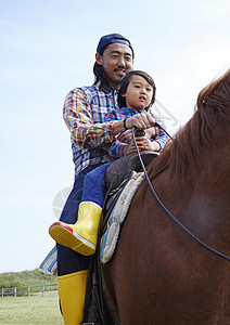 骑马的男人父亲带着孩子骑马背景