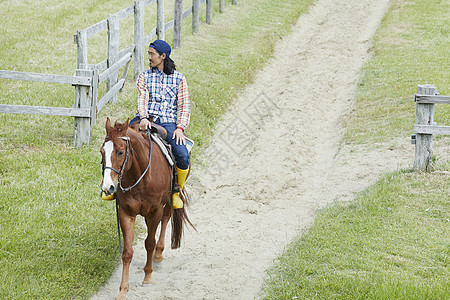 在牧场骑马的男子图片