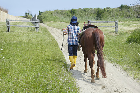 牧场里牵着马的男人背影图片素材