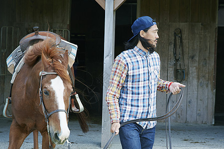 牧场里牵着马的男人图片