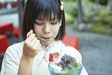 穿着日式服装的女孩吃沙冰背景图片