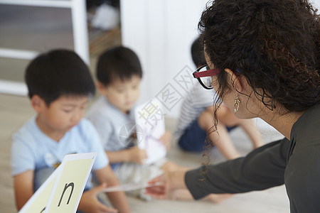 外语老师教幼儿园儿童学习英语会话的场景图片