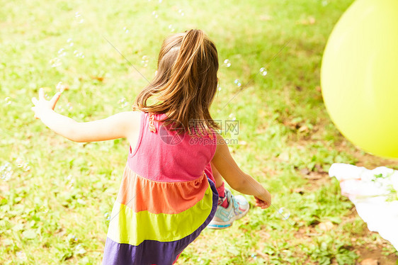 户外草地上孩子们玩肥皂泡泡图片