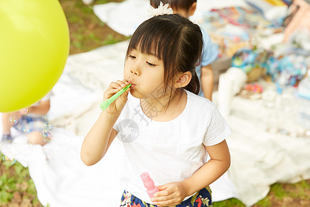 公园野餐的女孩玩肥皂泡泡图片