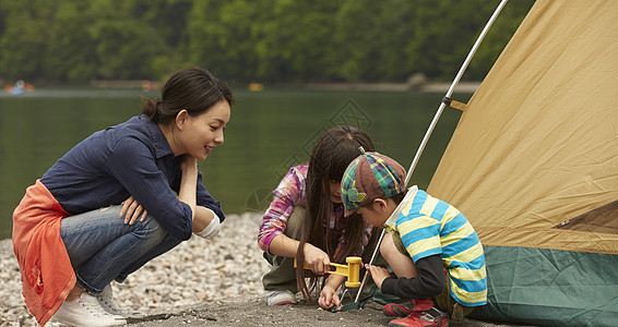 湖边教儿女搭帐篷的妈妈背景图片