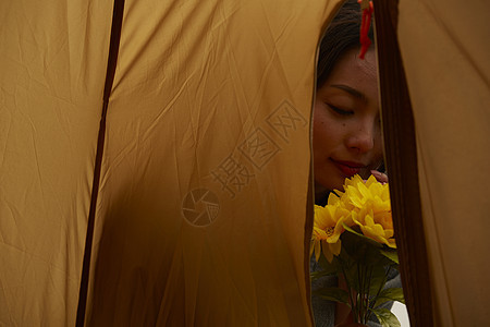 帐篷外欣赏花朵的女人肖像图片