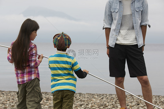 海边营地父亲带着孩子钓鱼图片