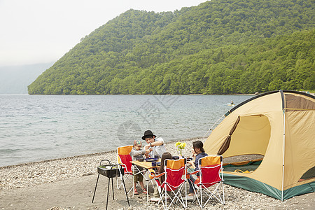 湖边露营地度假烧烤的家庭背景图片