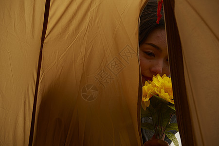 帐篷外欣赏花朵的女人肖像图片