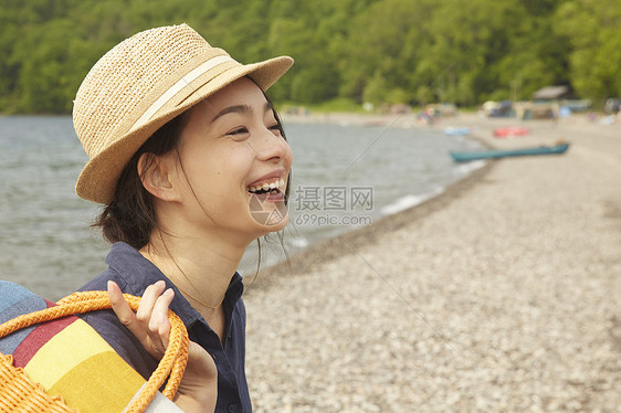 湖边微笑的女旅行者肖像图片