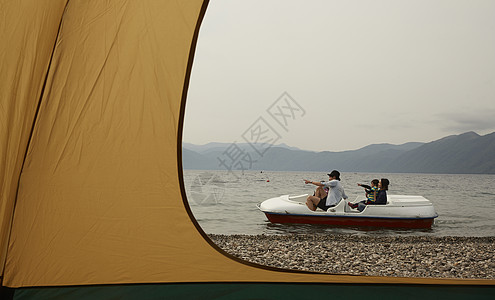 帐篷外玩脚踏船的四个人图片