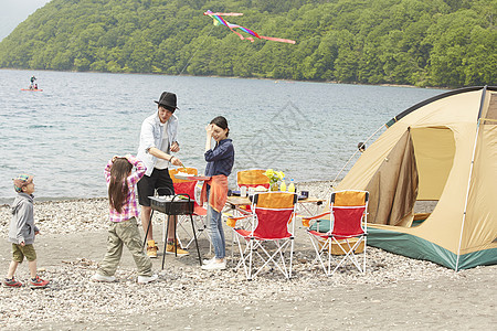 湖边露营烧烤的四口家庭图片