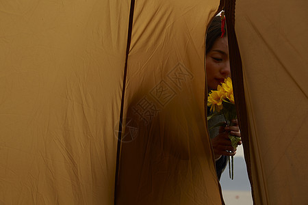 帐篷外闻花香的女人图片