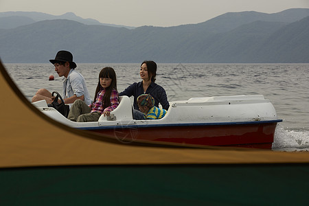 帐篷外坐脚踏船的4人图片