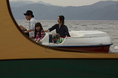 帐篷外坐脚踏船玩耍的4人图片