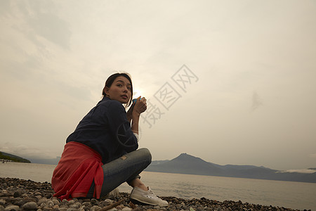 独自坐在湖边喝茶的女人肖像图片