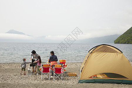 一家四口在海边搭帐篷露营图片