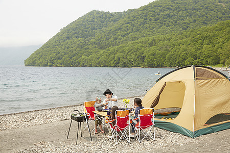 一家四口在海边搭帐篷露营烧烤图片