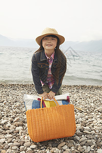 女孩拿着野餐包在海边图片