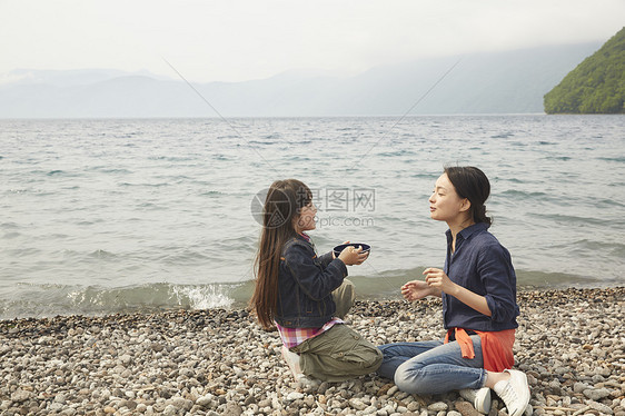 坐在湖边吃烧烤的母女图片