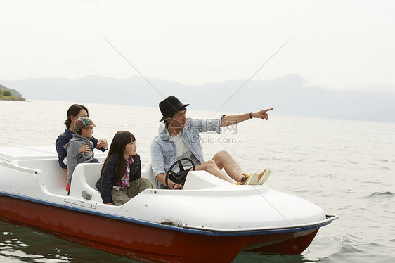 湖边开心坐脚踏船的4人图片