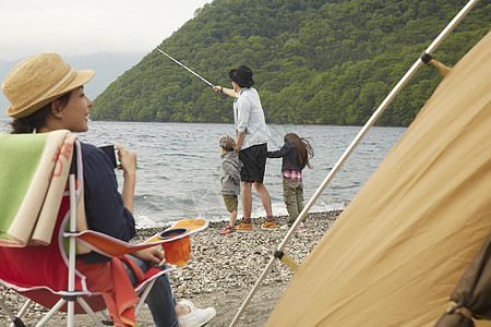 湖边露营地钓鱼的家庭图片