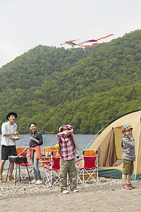 湖边露营烧烤放风筝的4人图片