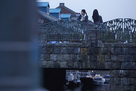 在桥上带着相机旅行的2个女生图片