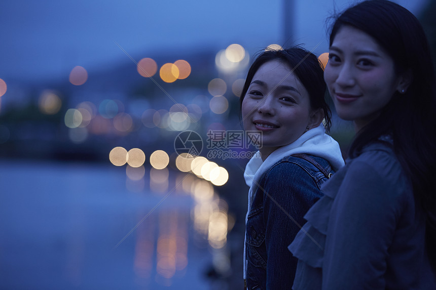 在桥上带着相机旅行的2个女生图片