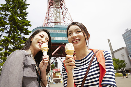 吃冰激凌带着相机旅行的2个女性图片