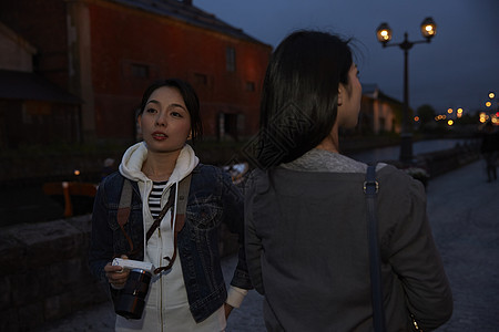 夜晚游客女人旅游观光拍照图片