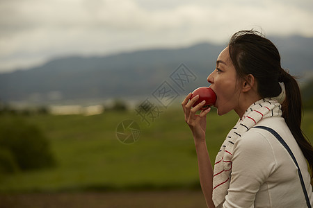 吃新鲜番茄的女青年图片