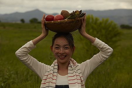 收获新鲜蔬菜的农民女青年图片