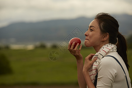 吃新鲜番茄的女青年图片