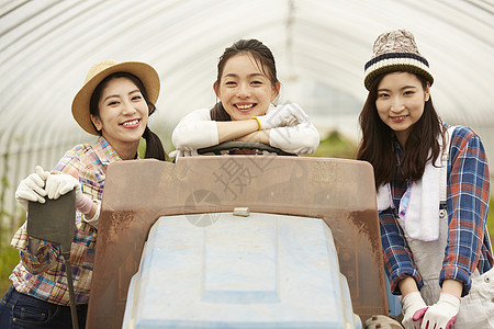三个女人坐在农耕机器上开心笑图片