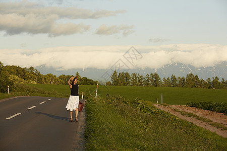 一个独自旅行的女人在路边图片