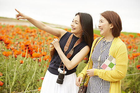 中年女人和朋友在花海里踏青图片