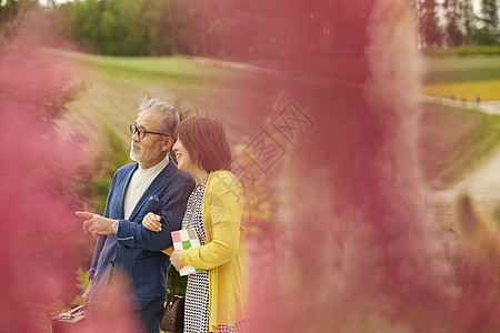 中年夫妇在花田里看风景图片