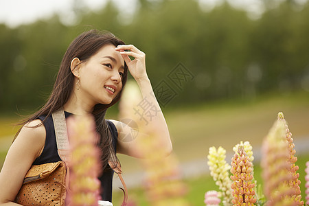 在花卉丛中漫步的女人图片