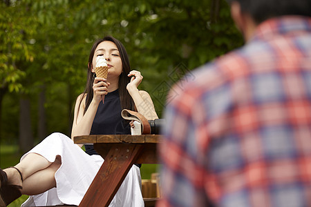 坐在长椅上吃冰淇淋的女人图片