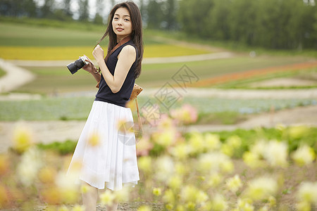 女人独自花海中拍照图片