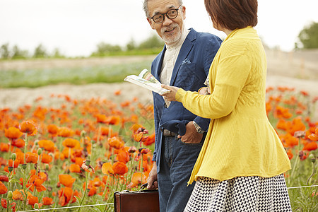 花园里拿着书本的中年夫妇图片