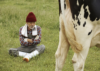 坐在草里上放牛的牧民图片
