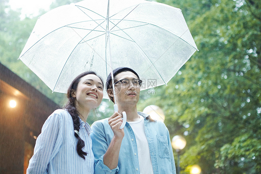 雨天撑伞漫步林间的情侣图片