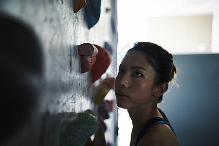 女生在健身房体验室内攀岩图片