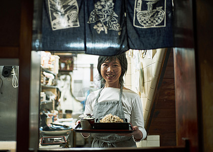 出餐口端着餐食的女服务员图片