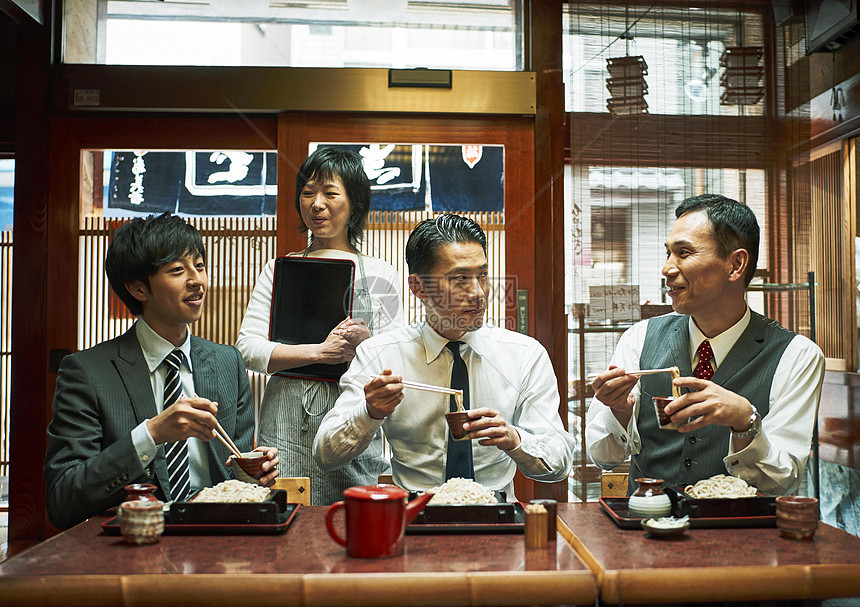 坐在小餐馆吃饭聊天的三个上班族