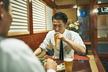 商务人士在居酒屋喝酒交谈图片