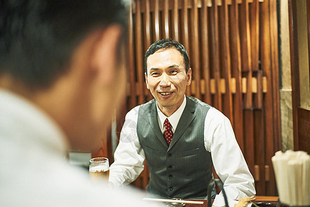 商务人士在居酒屋喝酒交谈图片