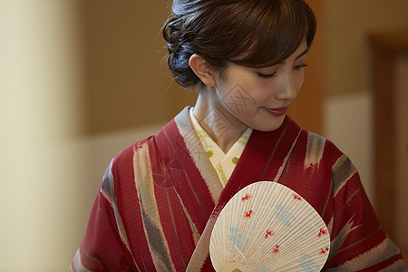 日本传统室内优雅拿扇子的穿和服的女性肖像背景